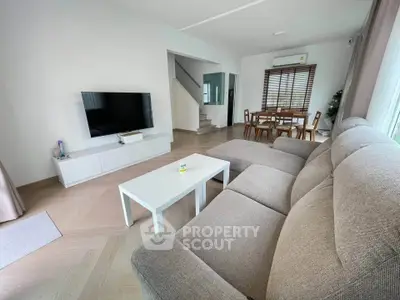 Spacious modern living room with stylish furniture and open dining area, perfect for family gatherings.