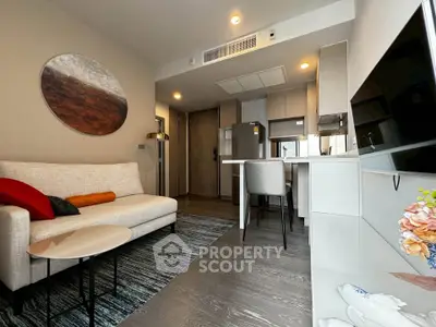 Modern living room with open kitchen, stylish decor, and cozy seating area in a contemporary apartment.