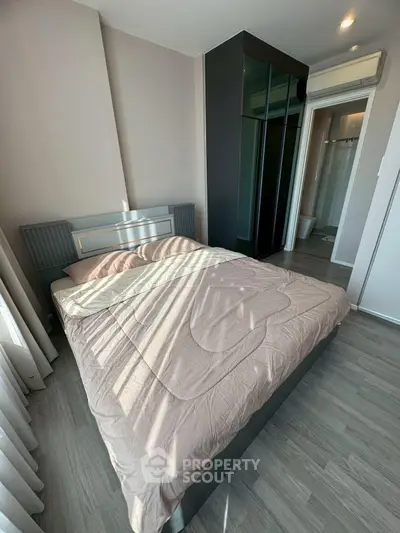 Modern bedroom with sleek design and natural light, featuring a cozy bed and stylish flooring.