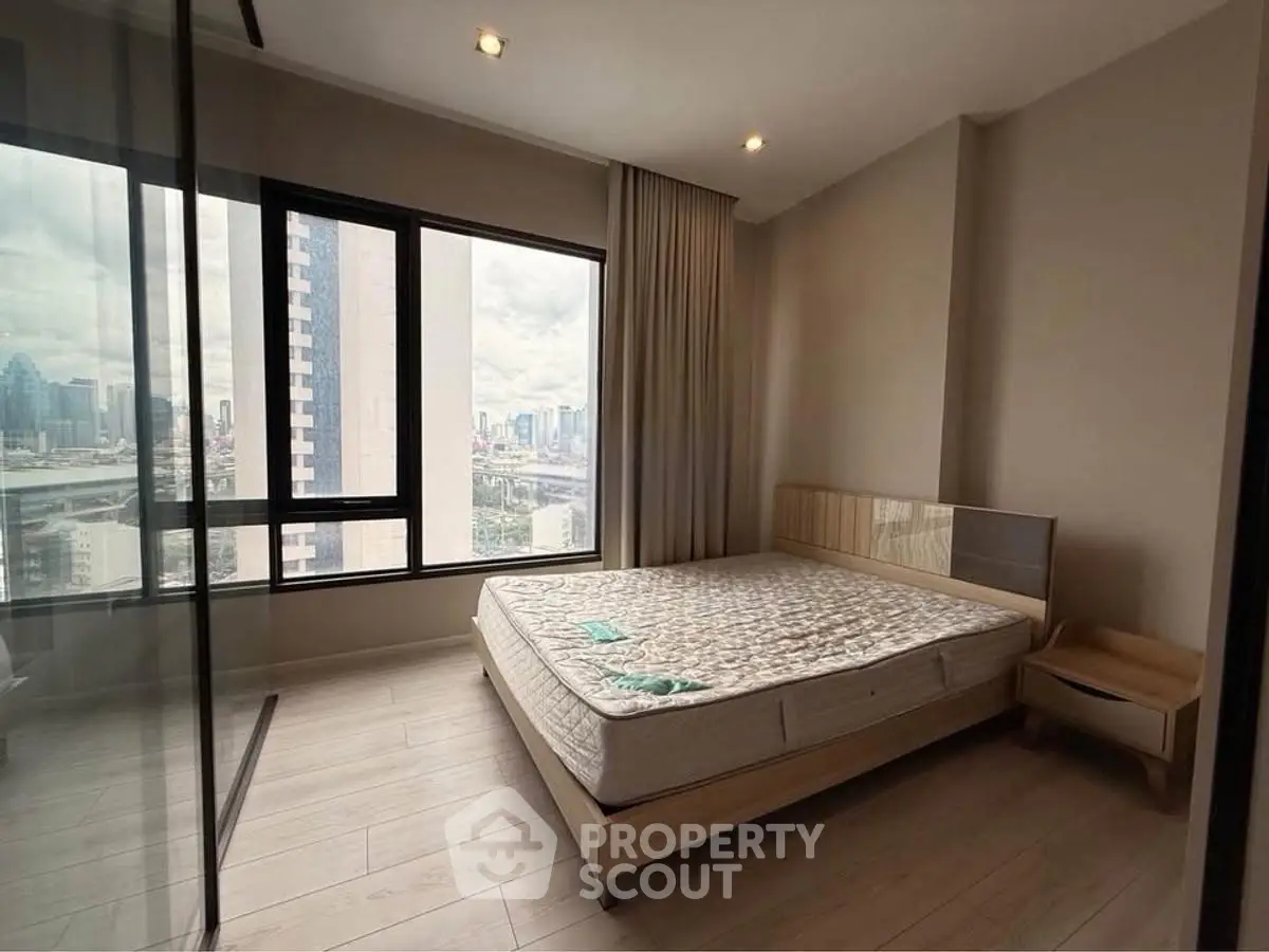 Spacious bedroom with city view and large windows in modern apartment