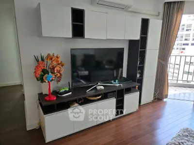 Modern living room with sleek entertainment unit and balcony view