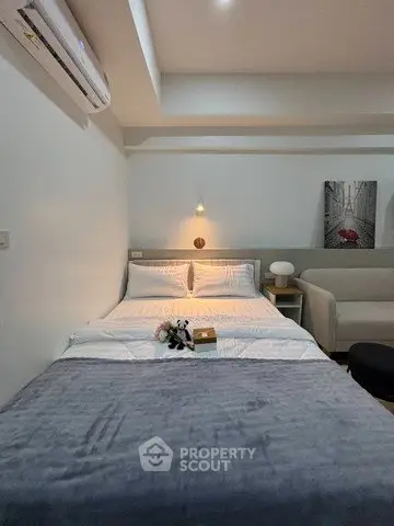 Cozy bedroom with modern decor and ambient lighting, featuring a comfortable bed and stylish artwork.