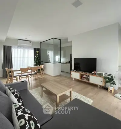 Modern living room with open layout, stylish furniture, and Christmas decor