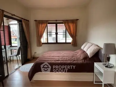 Cozy bedroom with balcony access and natural light, perfect for relaxation.