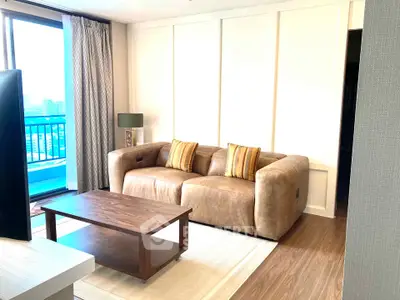 Stylish living room with modern leather sofa and city view balcony, perfect for urban living.