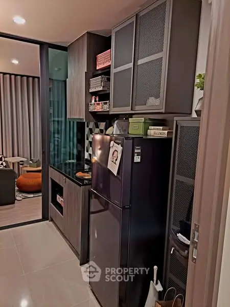 Modern kitchen with sleek cabinetry and black appliances in a stylish apartment.