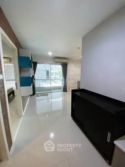 Spacious modern living room with glossy floors and balcony access in a stylish apartment.