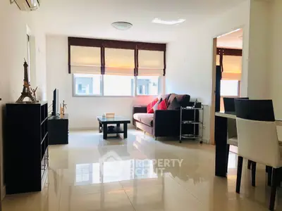 Bright and modern living room with sleek furniture and large windows in a stylish apartment.
