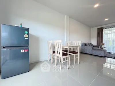 Modern living room with sleek fridge and dining set, open layout design