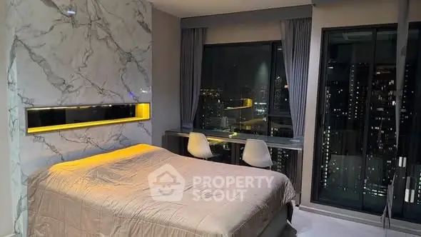 Luxurious bedroom with stunning city view and modern marble accent wall.