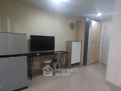 Modern apartment interior with fridge, TV, and stylish furniture