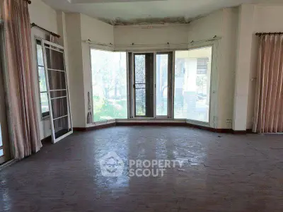 Spacious living room with large windows and natural light, ideal for modern living.