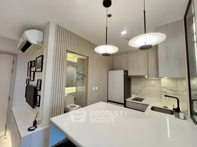 Modern kitchen with sleek design, featuring open layout and stylish lighting fixtures.