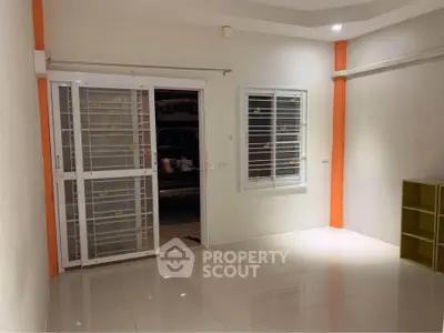 Spacious room with tiled floor and sliding door, ideal for versatile use.