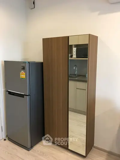 Modern kitchen corner with fridge and sleek wooden cabinet