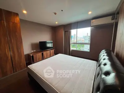 Spacious bedroom with city view, featuring modern furniture and ample natural light.