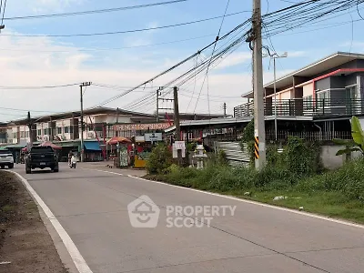 Street view of modern townhomes with clear sky and power lines, showcasing suburban living.