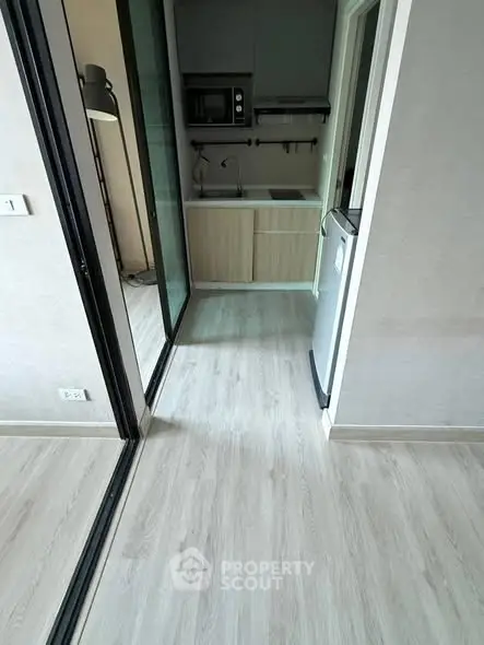 Modern compact kitchen with sleek appliances and light wood flooring