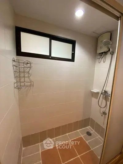 Modern bathroom with shower and tiled walls in a cozy real estate property.