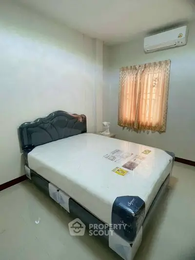 Cozy bedroom with air conditioning and natural light, perfect for relaxation.