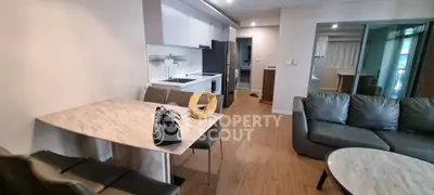 Modern open-plan living room with sleek kitchen and stylish dining area in a contemporary apartment.