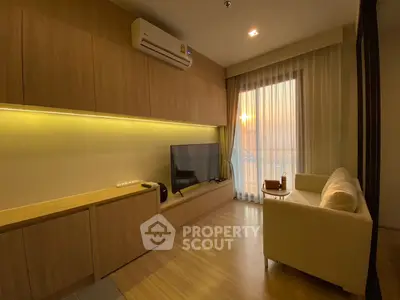 Modern living room with wooden accents, cozy sofa, and large TV, featuring a sunset view through sheer curtains.