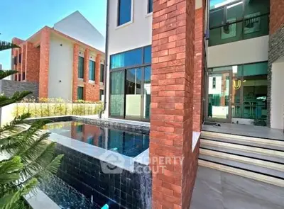 Modern luxury home with private pool and brick exterior, perfect for upscale living.
