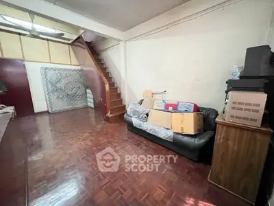 Spacious living room with wooden flooring and staircase, ideal for cozy family gatherings.