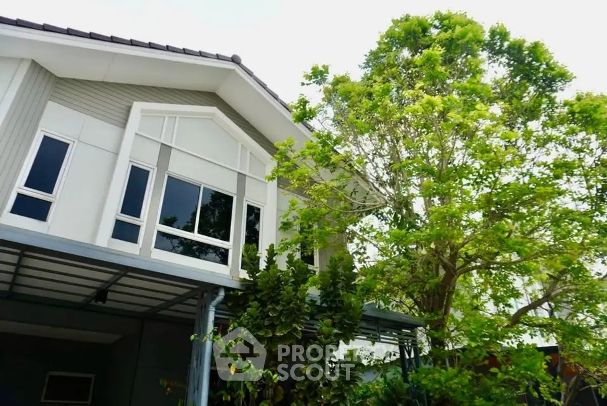 Charming modern house exterior with lush greenery and large windows