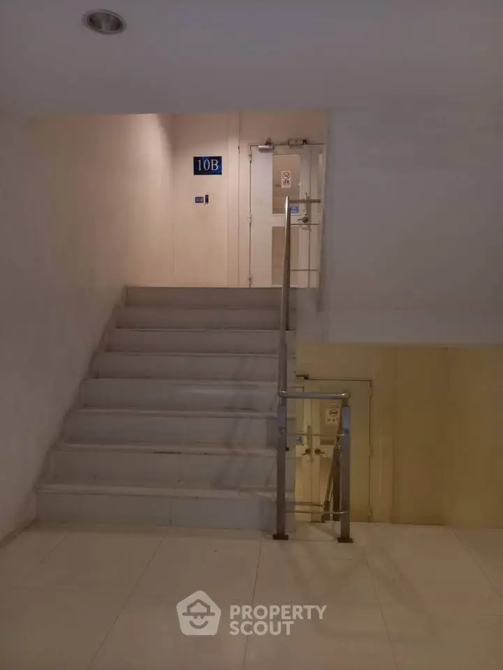 Spacious stairway in modern building with sleek design and bright lighting.