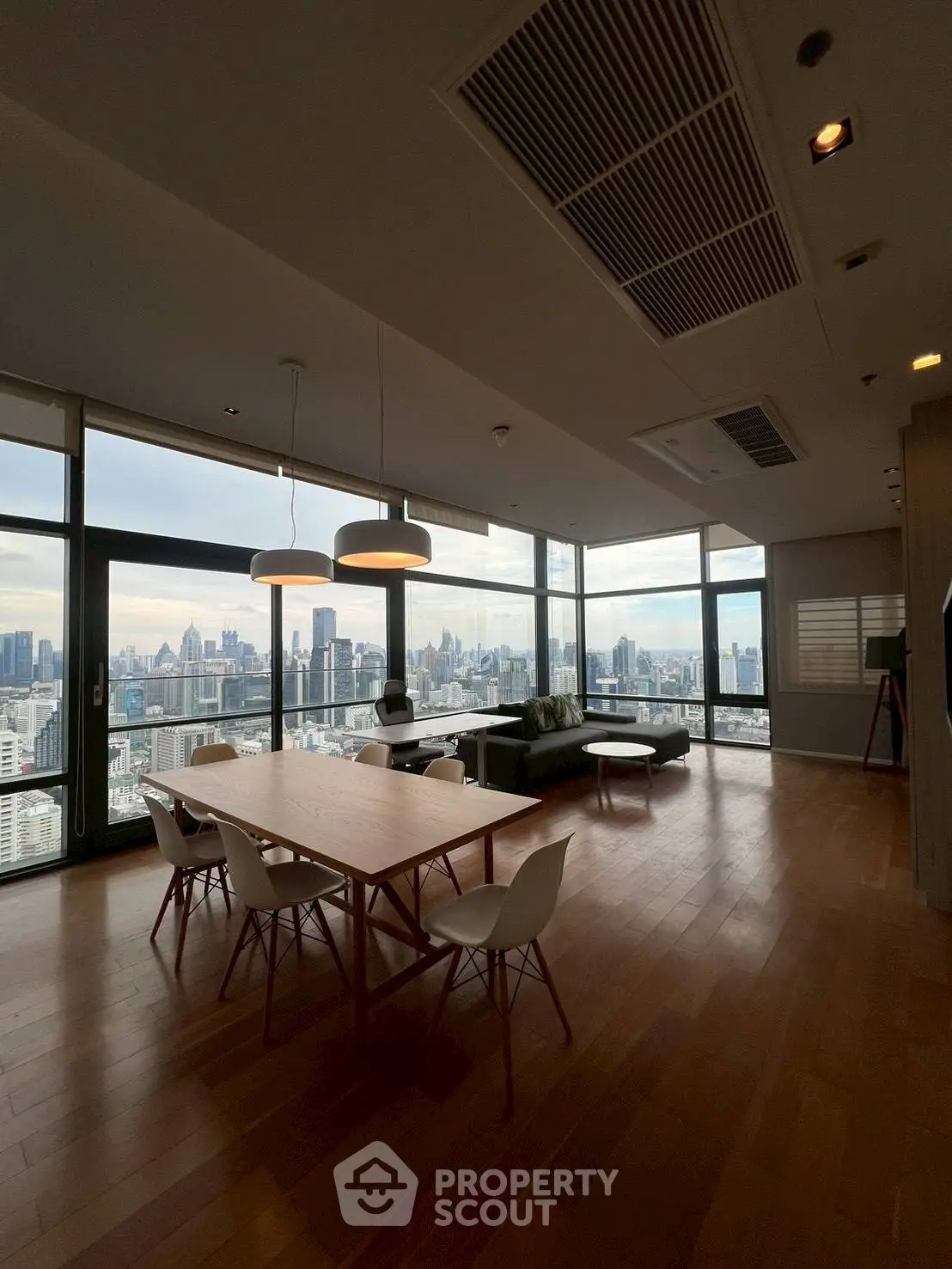 Spacious modern living room with stunning city view and elegant dining area.