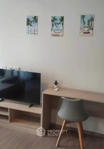 Modern living room with sleek TV stand and stylish desk, perfect for urban living.