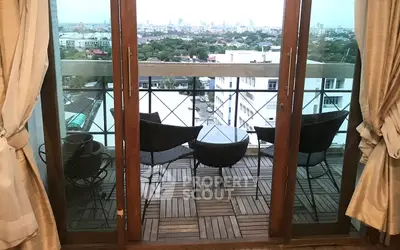 Charming balcony with city view, featuring cozy seating and elegant wooden flooring, perfect for relaxation.
