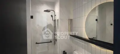 Modern bathroom with sleek shower and elegant lighting
