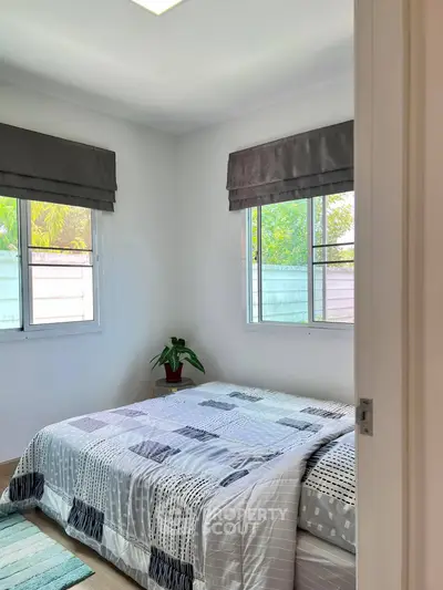 Cozy bedroom with natural light and modern decor, featuring a comfortable bed and stylish window treatments.