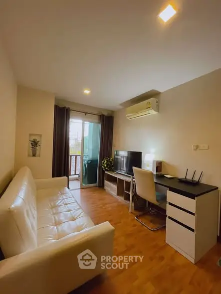 Cozy living room with modern furniture and balcony access in a stylish apartment.