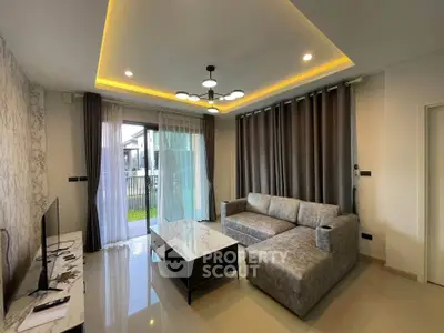 Modern living room with stylish lighting and large windows overlooking garden