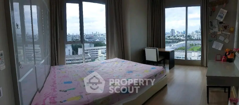 Spacious bedroom with large windows offering stunning city views, perfect for urban living.