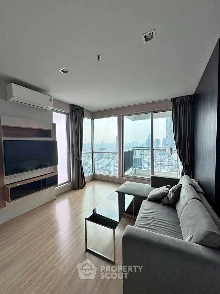 Spacious modern living room with panoramic city views and sleek furnishings.