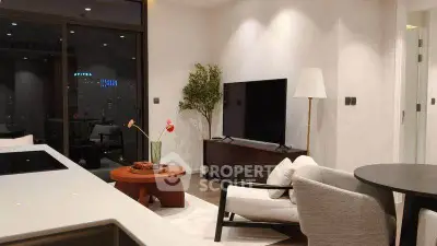 Modern living room with sleek furniture and large TV, offering a cozy and stylish ambiance.