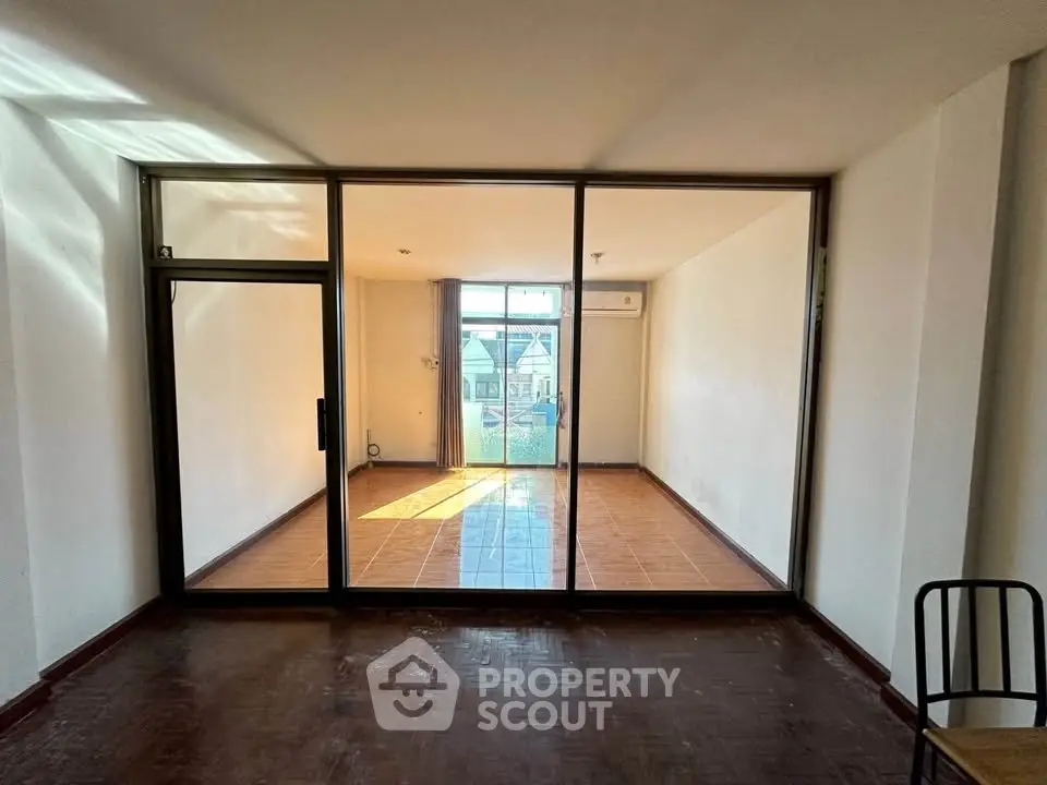 Spacious room with glass partition and balcony access, ideal for modern living.