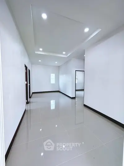 Spacious modern interior with glossy tiled floors and recessed lighting, perfect for customization.