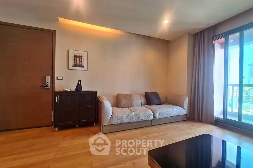 Modern living room with cozy sofa and wooden flooring, featuring a large window with city view.