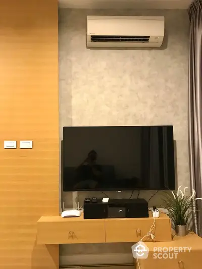 Modern living room with wall-mounted TV and air conditioning unit