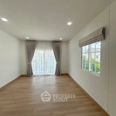 Spacious empty room with large window and elegant curtains, perfect for customization.