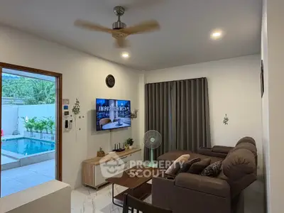 Modern living room with pool view, featuring cozy seating and stylish decor.