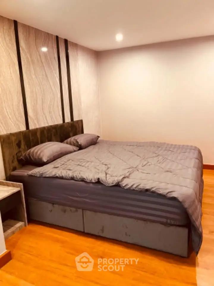 Modern bedroom with stylish decor and cozy bedding in a contemporary apartment.