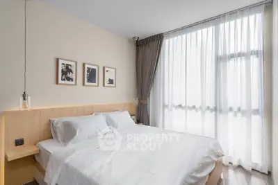 Modern bedroom with large window and stylish decor in a contemporary apartment.