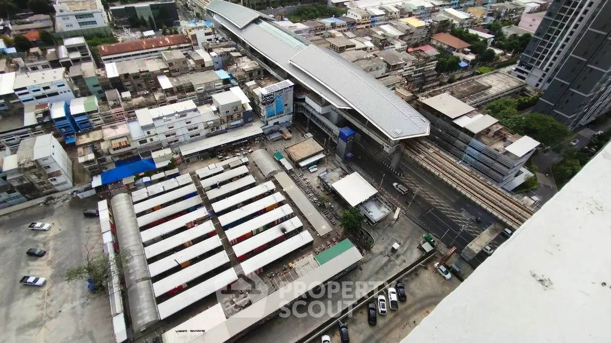 Aerial view of urban buildings and a train station, showcasing city infrastructure and development.