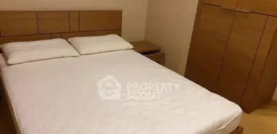 Cozy bedroom with wooden furniture and comfortable bedding.